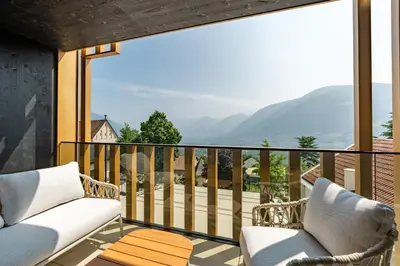 a balcony with chairs and a view of the mountains at Alea Living in Tirolo