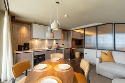 a kitchen and dining room with a table and chairs at Alea Living in Tirolo
