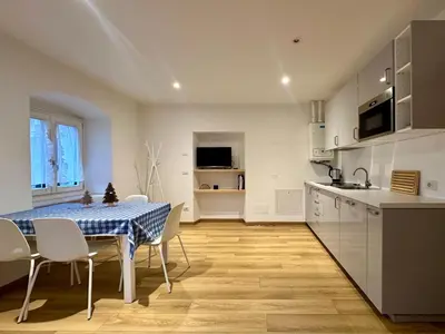 a kitchen and dining room with a table and chairs at La Busa dai Zervi in Daiano