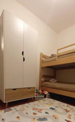a bedroom with a white cabinet next to a bunk bed at Appartamento Cuore delle Dolomiti in Cencenighe