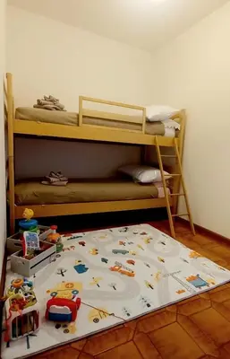 a childs bunk bed with toys on the floor at Appartamento Cuore delle Dolomiti in Cencenighe