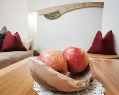 two apples in a wooden bowl on a table at Apartment Schmetterling in Collalbo