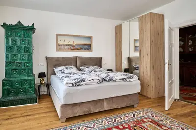 a bedroom with a bed and a green cabinet at Villa Donata - Luxuriöses & großzügiges Apartment im Herzen von Kaltern, mit Innenhof, kostenlosem Parkplatz direkt am Haus in Caldaro