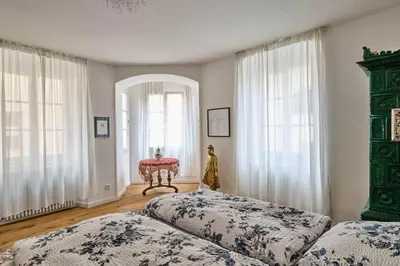 a bedroom with two beds and two windows at Villa Donata - Luxuriöses & großzügiges Apartment im Herzen von Kaltern, mit Innenhof, kostenlosem Parkplatz direkt am Haus in Caldaro