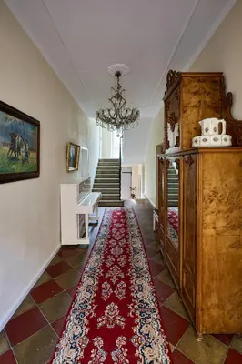 a hallway with a red rug on the floor at Villa Donata - Luxuriöses & großzügiges Apartment im Herzen von Kaltern, mit Innenhof, kostenlosem Parkplatz direkt am Haus in Caldaro