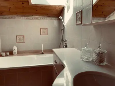 a bathroom with a bath tub and a sink and a bath tub at Snowflake Apartment in Moena