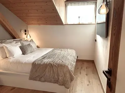 a bedroom with a white bed with a window at Snowflake Apartment in Moena