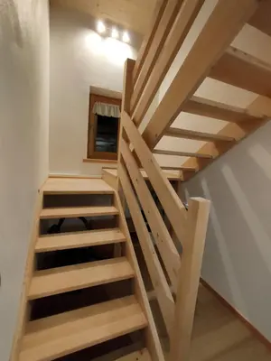 a room with a wooden staircase and a wooden door at Gianni Rocca Apartments APPARTAMENTO PIANO 1 E 2 in Rocca Pietore