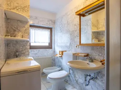 a bathroom with a toilet and a sink and a mirror at Apartment Fontanelle-4 by Interhome in Alba di Canazei