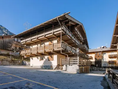 an apartment building in the mountains with a parking lot at Apartment Fontanelle-4 by Interhome in Alba di Canazei