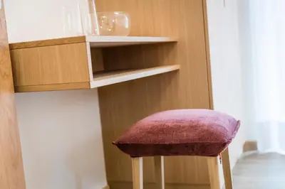 a stool with a pink seat sitting under a shelf at Moderne panorama Apartments in den Dolomiten, 2min von den Liften in Selva di Val Gardena