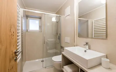 a bathroom with a sink and a shower and a toilet at Moderne panorama Apartments in den Dolomiten, 2min von den Liften in Selva di Val Gardena