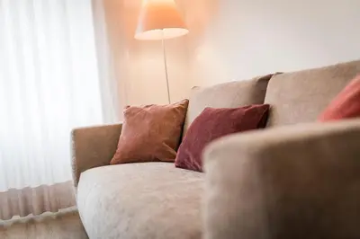 a couch with pillows sitting next to a window at Moderne panorama Apartments in den Dolomiten, 2min von den Liften in Selva di Val Gardena