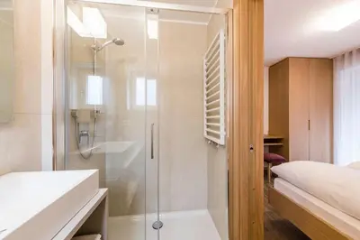 a bathroom with a shower with a glass door at Moderne panorama Apartments in den Dolomiten, 2min von den Liften in Selva di Val Gardena