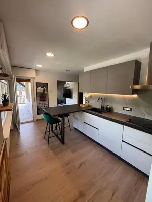 a kitchen with a counter and a table in it at Casa GOLLES - Val Di Fiemme in Castello di Fiemme