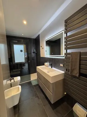 a bathroom with a sink and a toilet and a mirror at Casa GOLLES - Val Di Fiemme in Castello di Fiemme
