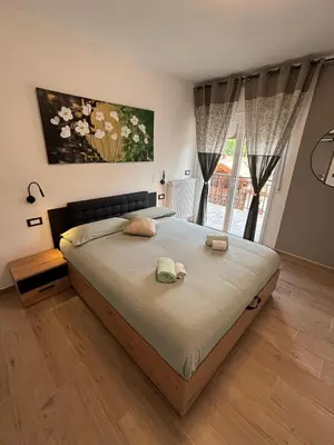 a bedroom with a bed and a large window at Casa GOLLES - Val Di Fiemme in Castello di Fiemme
