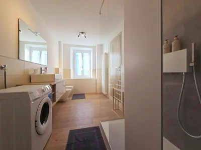 a bathroom with a washing machine and a sink at Casetta sui Monti - Alpine Stay Apartments in Tesero