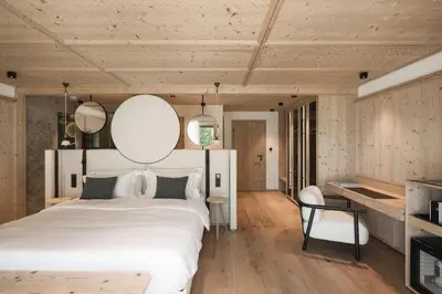 a house on a hill with mountains in the background at Muliné Lodge in Selva di Val Gardena