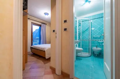 a bathroom with a shower and a bed and a toilet at Cesa Malvi in Canazei