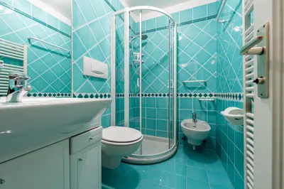 a blue bathroom with a toilet and a sink at Cesa Malvi in Canazei