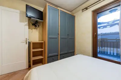 a bedroom with a bed and a tv and a window at Cesa Malvi in Canazei