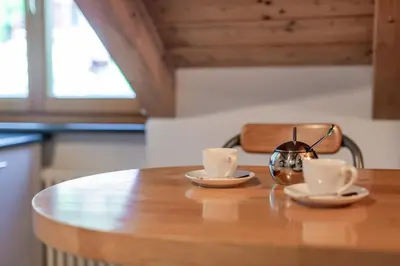 two cups of coffee on a wooden table with a purse at Maison sous le ciel in Caldaro