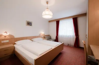 a bedroom with a large bed and a window at Apartment Hotel Elvis in Ortisei
