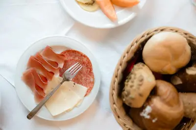 a table with plates of food and a basket of food at Apartment Hotel Elvis in Ortisei