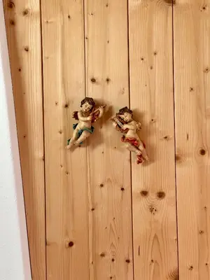 two dolls sitting on top of a wooden wall at Scurcia in Ortisei