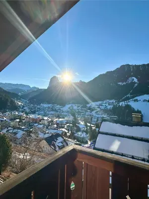 a view from a balcony of a town with the sun setting at Scurcia in Ortisei