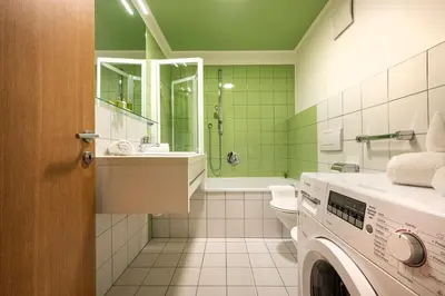 a bathroom with a washing machine and a washer at Residence Petlin Robert in Ortisei
