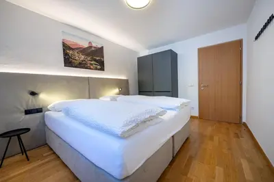 a large white bedroom with a large white bed at Residence Petlin Robert in Ortisei