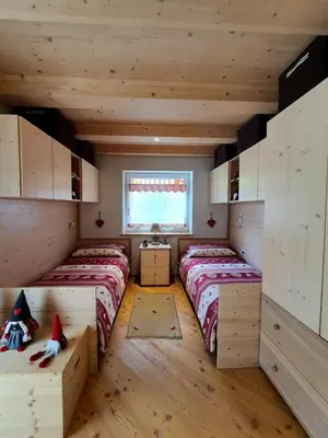 a room with two beds and a window at Casa Sandra Moena by Go new Location in Moena