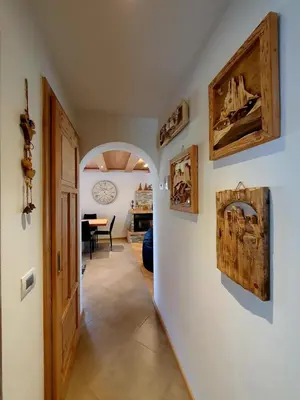 a hallway with an archway with paintings on the walls at Casa Sandra Moena by Go new Location in Moena