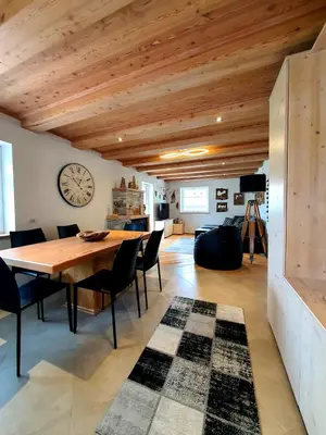 a dining room with a table and chairs and a clock at Casa Sandra Moena by Go new Location in Moena