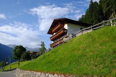 a building on the side of a grassy hill at Ausserstauderhof in San Leonardo in Passiria