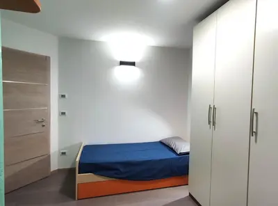 a small bedroom with a bed and a closet at Casa Elisa apartment in Ronzone