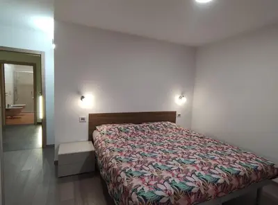 a bedroom with a bed and a bathroom at Casa Elisa apartment in Ronzone