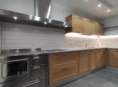 a kitchen with stainless steel appliances and wooden cabinets at Casa Elisa apartment in Ronzone