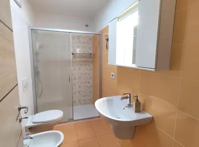 a bathroom with a toilet and a sink and a shower at Casa Elisa apartment in Ronzone