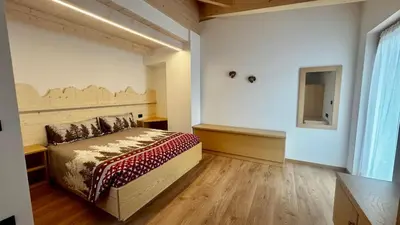 a bedroom with a bed and a mirror on the wall at Lares - Your nordic stay in Tesero