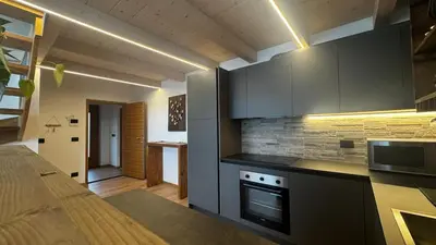 a kitchen with gray cabinets and a counter top at Lares - Your nordic stay in Tesero