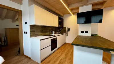 a kitchen with white cabinets and a counter top at Pecio - Your nordic stay in Tesero