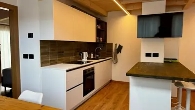a kitchen with white cabinets and a counter top at Pecio - Your nordic stay in Tesero