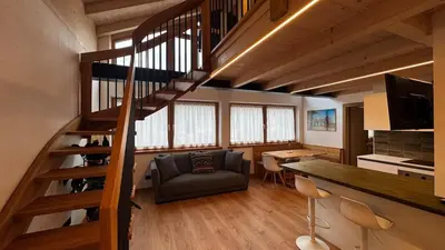 a living room with a spiral staircase and a couch at Pecio - Your nordic stay in Tesero