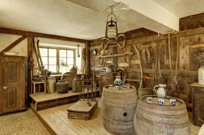 a room with two large wooden barrels and a chandelier at Gattererhof in Schenna