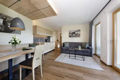 a kitchen and living room with a couch and a table at Gattererhof in Schenna