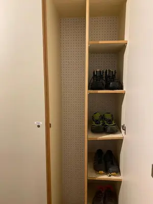a closet with several shelves with shoes in it at Appartamento ai piedi delle Dolomiti in Selva di Val Gardena