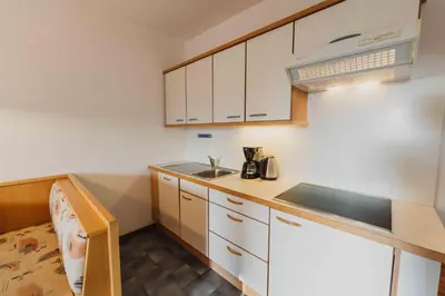 a small kitchen with white cabinets and a sink at Appartements Elke in Lagundo
